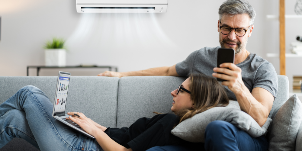 Confort énergétique grâce aux solutions de climatisation et chauffage écologiques Couple relaxant dans un salon moderne, profitant du confort offert par un système de climatisation écologique